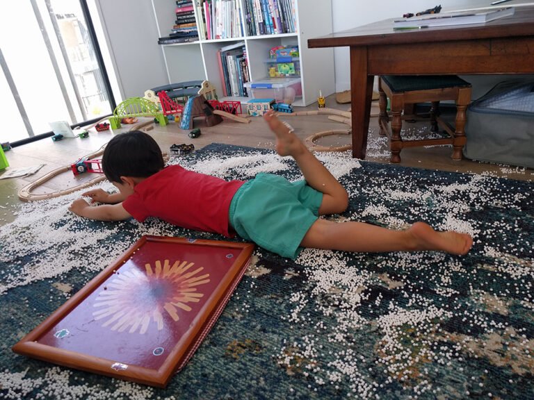 Boy lying on the floor surrounded by polystyrene balls