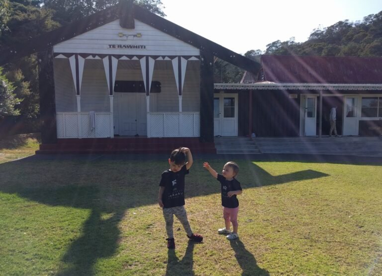 Two tamariki in front of their marae